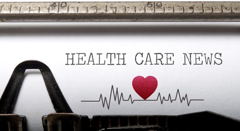 Health care news printed on an old typewriter with heart beat pulse sketch