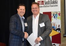 SDAHO Board Chair Curt Hohman congratulates Paul Hanson, executive vice president of Sanford USD Medical Center in Sioux Falls, on receiving an AHA PAC MVPP award.