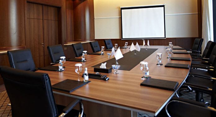 Conference room with a big polished table and arm-chairs