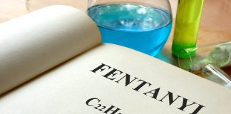 Book with fentanyl and test tubes on a table.
