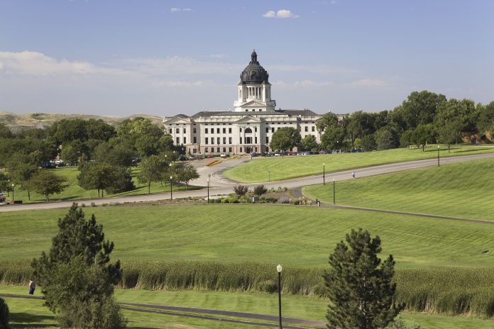 Green grass of park leading to South Dakota State Capitol and co