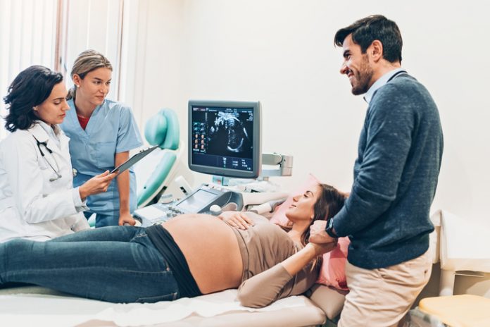 Husband and pregnant wife together at the doctor's office