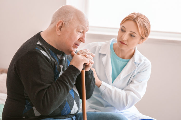 Elderly man suffering from mental disability with doctor at home